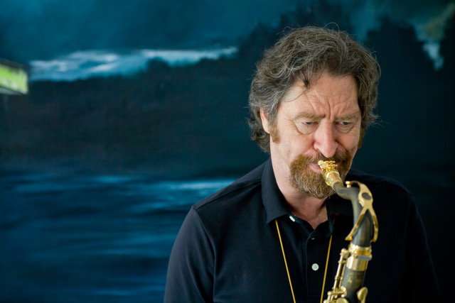 Daniel Guggenheim playing alto saxophone in front of a blue stage backdrop — Photo: Henning Goll